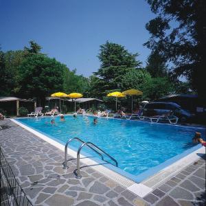 una gran piscina con gente con sombrillas en Camping Garden Tourist, en Manerba del Garda