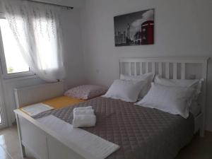 1 dormitorio con cama blanca y almohadas blancas en Villa Dimitri - SeaView Apartment en Alejandrópolis
