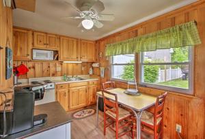 a kitchen with a table and chairs and a window at Beachfront Sebago Cottage with Deck and Grill! in North Sebago