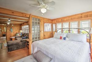a bedroom with a bed and a couch and a ceiling fan at Beachfront Sebago Cottage with Deck and Grill! in North Sebago