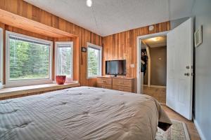 a bedroom with a bed and a tv and windows at Convenient Kenai Apt - 3 Mi to Beach and Fishing in Kenai