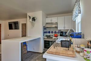 une cuisine avec des placards blancs et un comptoir dans l'établissement Cottage with Patio and Grill - 25 Min to Taos Valley!, à El Prado