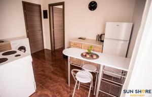 eine Küche mit einem weißen Kühlschrank sowie einem Tisch und Stühlen in der Unterkunft Explore Greece from Lovely City Centre Apartment in Chalkida