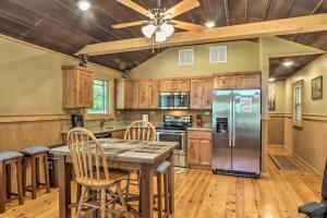 a kitchen with a table and a refrigerator at Guntersville Lake Cabin with 3 Fishing Ponds! in Guntersville