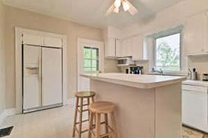a kitchen with white cabinets and a counter and stools at Millburn House with Deck - Walk to NYC Transit! in Millburn