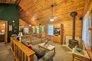 a living room with a fireplace in a log cabin at Eureka Springs Studio with Deck, Views and BBQ! in Eureka Springs