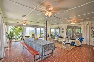 sala de estar con mesa y ventilador de techo en Charming Summerville Home with Yard and Sunroom!, en Summerville