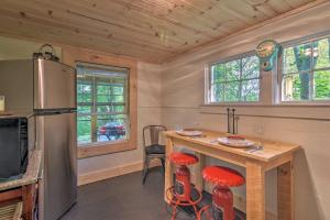 Il comprend une cuisine équipée d'un réfrigérateur et d'une table avec des tabourets. dans l'établissement Cozy Candler Cottage - 11 Mi to DT Asheville!, à Candler