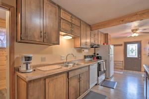 a kitchen with wooden cabinets and a white refrigerator at Cabin 6 Mi to Burr Trail, 32 Mi to Escalante! in Boulder Town