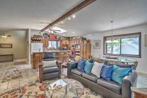 a living room with a couch and a kitchen at Lake of the Ozarks Home with Game Room, BBQ and Dock! in Osage Beach