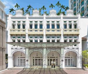 新加坡InterContinental Singapore by IHG的一座白色的建筑,前面有两个人