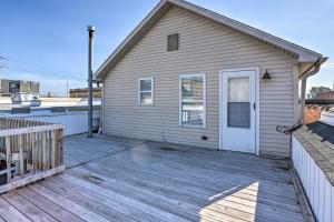 a house with a wooden deck with a white door at Updated Lake Erie Home 30 Min to Cedar Point! in Lorain