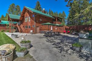 une cabane en rondins avec des tables et des chaises en face de celle-ci dans l'établissement Trego Resort -Style Cabin with Lake,Trails and 40 Acres, à Trego