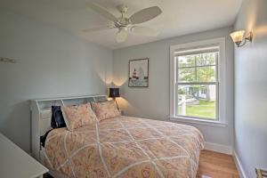 a bedroom with a bed with a ceiling fan and a window at Money Island Home with Deck, Kayak and Paddleboards! in Branford