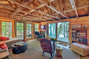 una sala de estar con un sofá y una mesa en Cozy Lakefront Madison Cabin with Dock and Kayaks, en Madison