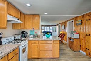 a kitchen with wooden cabinets and a white stove top oven at Cozy Hampton Cottage - Walk to Beaches and Marina! in Hampton