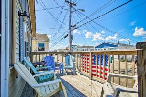 a porch with blue chairs on a house at Cozy Hampton Cottage - Walk to Beaches and Marina! in Hampton