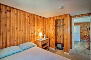 a bedroom with wooden walls and a bed and a desk at Cozy Hampton Cottage - Walk to Beaches and Marina! in Hampton