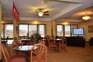 ein Restaurant mit Tischen und Stühlen und einem Flachbild-TV in der Unterkunft Baymont by Wyndham Fayetteville in Fayetteville