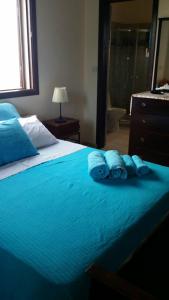 Un dormitorio con una cama con toallas azules. en Villa Bella Vista, en Droushia