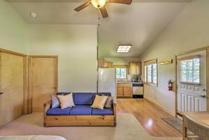 sala de estar con sofá azul y cocina en 40-Acre Trego Resort Cabin with Lake and Trails!, en Trego