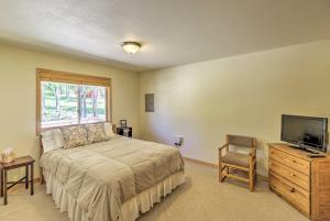 1 dormitorio con 1 cama, TV y silla en 40-Acre Trego Resort Cabin with Lake and Trails!, en Trego