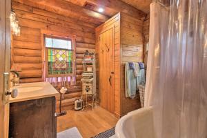 La salle de bains est pourvue d'une baignoire et d'un lavabo dans une cabane en rondins. dans l'établissement Inn the Woods Family Cabin with Hot Tub and Fire Pit, à Wimberley