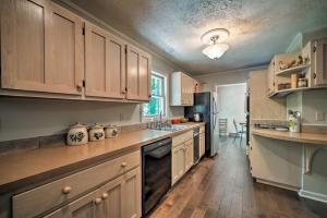 a kitchen with wooden cabinets and a stove top oven at Waterfront Lake Barkley Home with Deck and Fire Pit! in Cadiz