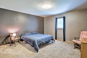 a bedroom with a blue bed and a window at Elwood Townhome with Patio - 7 Mi to Johnson Lake in Elwood +20 photos