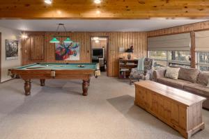 a living room with a pool table and a couch at Falcon Cabin in Fairmont Hot Springs