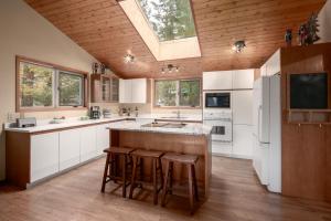 a kitchen with white cabinets and a skylight at Falcon Cabin in Fairmont Hot Springs