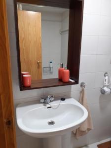 La salle de bains est pourvue d'un lavabo blanc et d'un miroir. dans l'établissement PASEO DE LOS AYERBE Nº5, à Canfranc-Estación