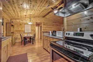 a kitchen with a stove and a dining table at Broken Bow Starlight Cabin with Private Hot Tub! in Broken Bow
