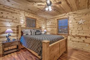 a bedroom with a bed in a log cabin at Broken Bow Starlight Cabin with Private Hot Tub! in Broken Bow