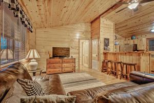 a living room with a couch and a kitchen at Broken Bow Starlight Cabin with Private Hot Tub! in Broken Bow