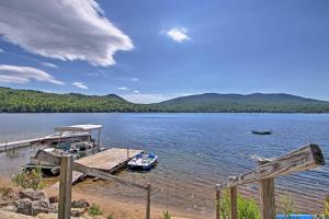 a boat is docked at a dock on a lake at Pet-Friendly Rumney Cabin on Stinson Lake! in Rumney