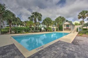 a swimming pool with palm trees and a house at Destin Townhome with Beach Access & 2 Pools! in Destin