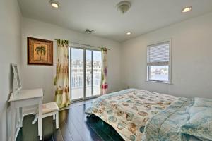 大西洋城的住宿－Home with Water Views, 1 Mi to BoardwalkandCasinos，一间卧室配有一张床、一张书桌和一个窗户。