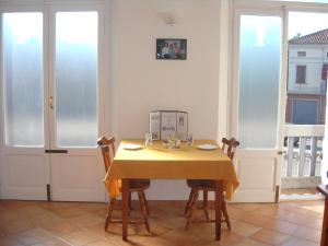 a dining room with a yellow table and chairs at Charlie Chaplin in Tamara