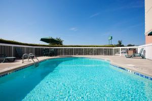 une piscine d'eau bleue et une clôture dans l'établissement Country Inn & Suites by Radisson, Goldsboro, NC, à Goldsboro