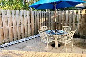 una mesa y sillas con una sombrilla en el patio en Gorgeous Beachy Chic Condo in Key Biscayne en Miami