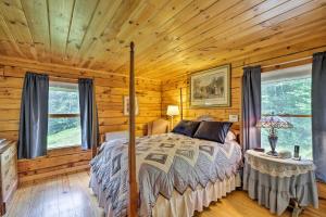 - une chambre avec un lit dans une cabane en rondins dans l'établissement Jacksonville Cabin with Wraparound Deck and Views, à Jacksonville