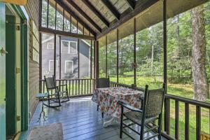 a screened in porch with a table and chairs at Saranac Lake Cabin with Beach Access in Lake Clear