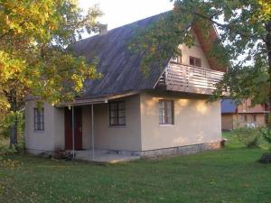 una pequeña casa blanca con techo negro en Andrese Holiday Home, en Muratsi