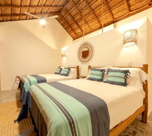 
a hotel room with two beds and two lamps at Mimosa Tulum in Tulum
