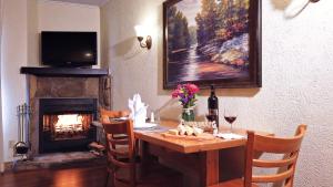 The Christie Lodge – All Suite Property Vail Valley/Beaver Creek في آفون: غرفة طعام مع طاولة ومدفأة