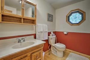 a bathroom with a toilet and a sink and a window at Jacksonville Cabin with Wraparound Deck and Views in Jacksonville +17 photos