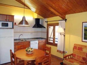 カンポにあるApartamentos Turismo Rural Casa Santorromanのキッチン(木製テーブル付)、キッチン(シンク付)