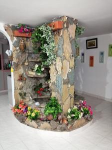 a stone wall with flowers and plants on it at Hostal Dante in San Gil