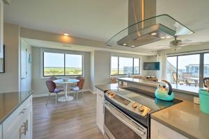 a kitchen with a stove top oven next to a table at Carolina Beach Home with Views and Pool Access! in Carolina Beach